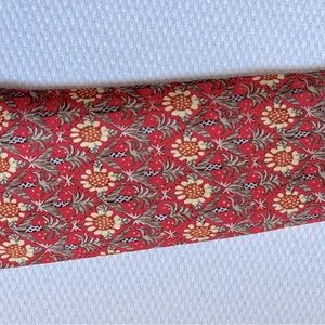 Preowned Hermes silk tie. Burnt orange with sunflowers and pineapple trees.